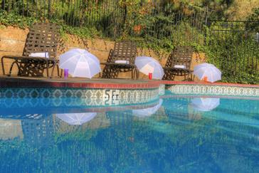 Pacific Plaza Hotels | Alameda, California | Pool area with lounge chairs and white umbrellas